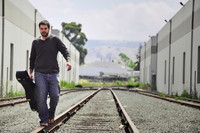 dan with guitar on railroad tracks